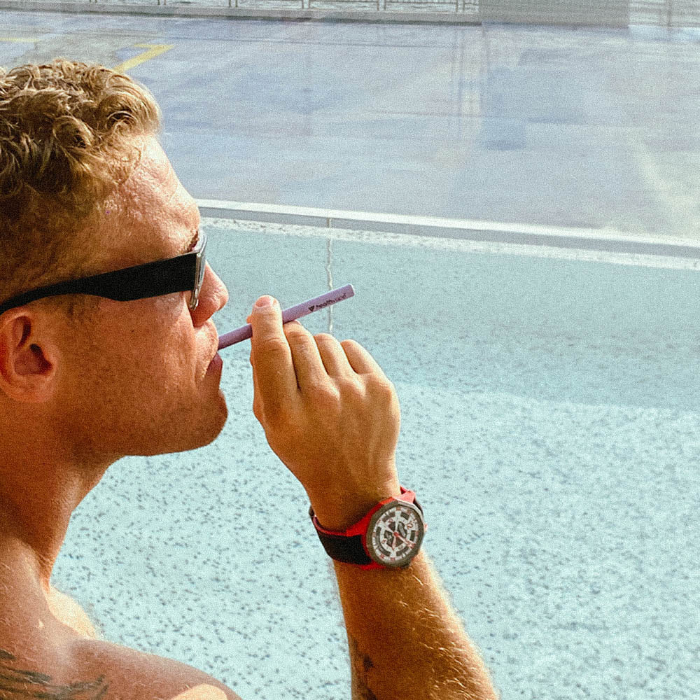 Man using HealthVape Chill Lavender disposable vape pen by the poolside