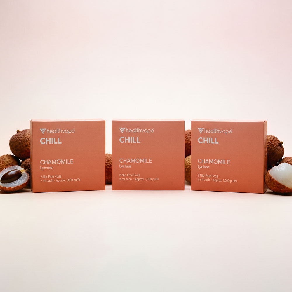 Three HealthVape CHILL Lychee pod boxes with fresh lychee garnish