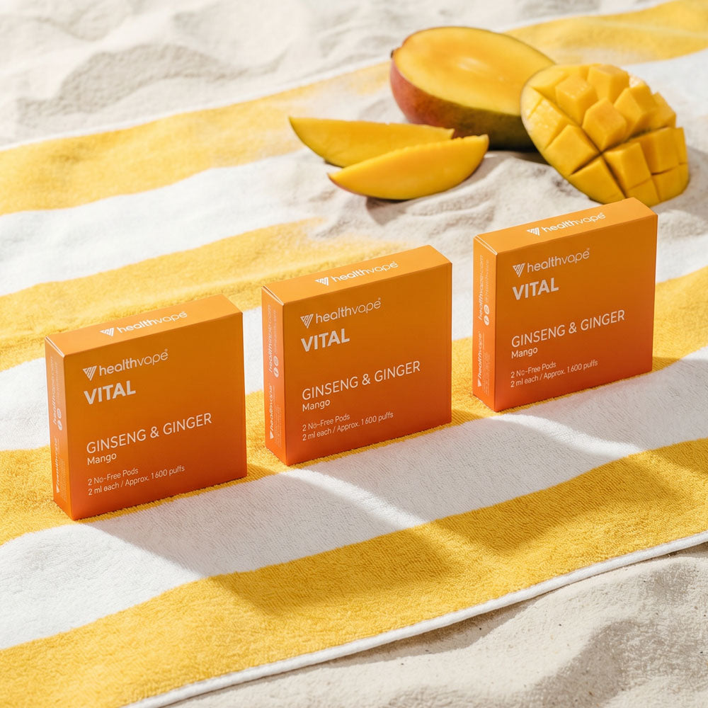 Three HealthVape VITAL Mango pod boxes with fresh mango garnish