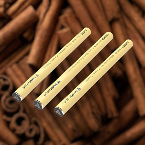 Three HealthVape ENERGY Cinnamon caffeine pens on cinnamon stick background