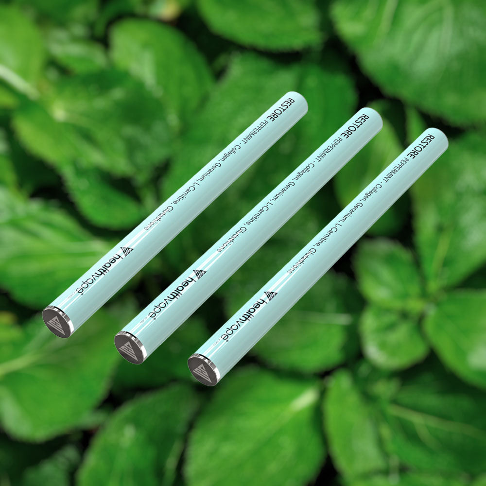 Three HealthVape RESTORE Peppermint collagen pens on fresh mint background